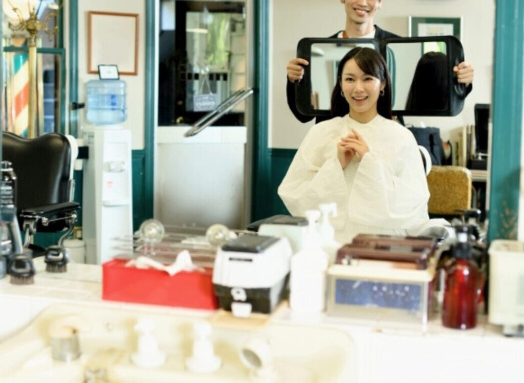 美容サロンでの丁寧なカウンセリングシーン - スタイリストが鏡を使って顧客と仕上がりイメージを共有