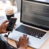 フリーランスエンジニアが複数のモニターでコーディングとシステム開発をしている