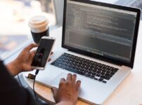 フリーランスエンジニアが複数のモニターでコーディングとシステム開発をしている